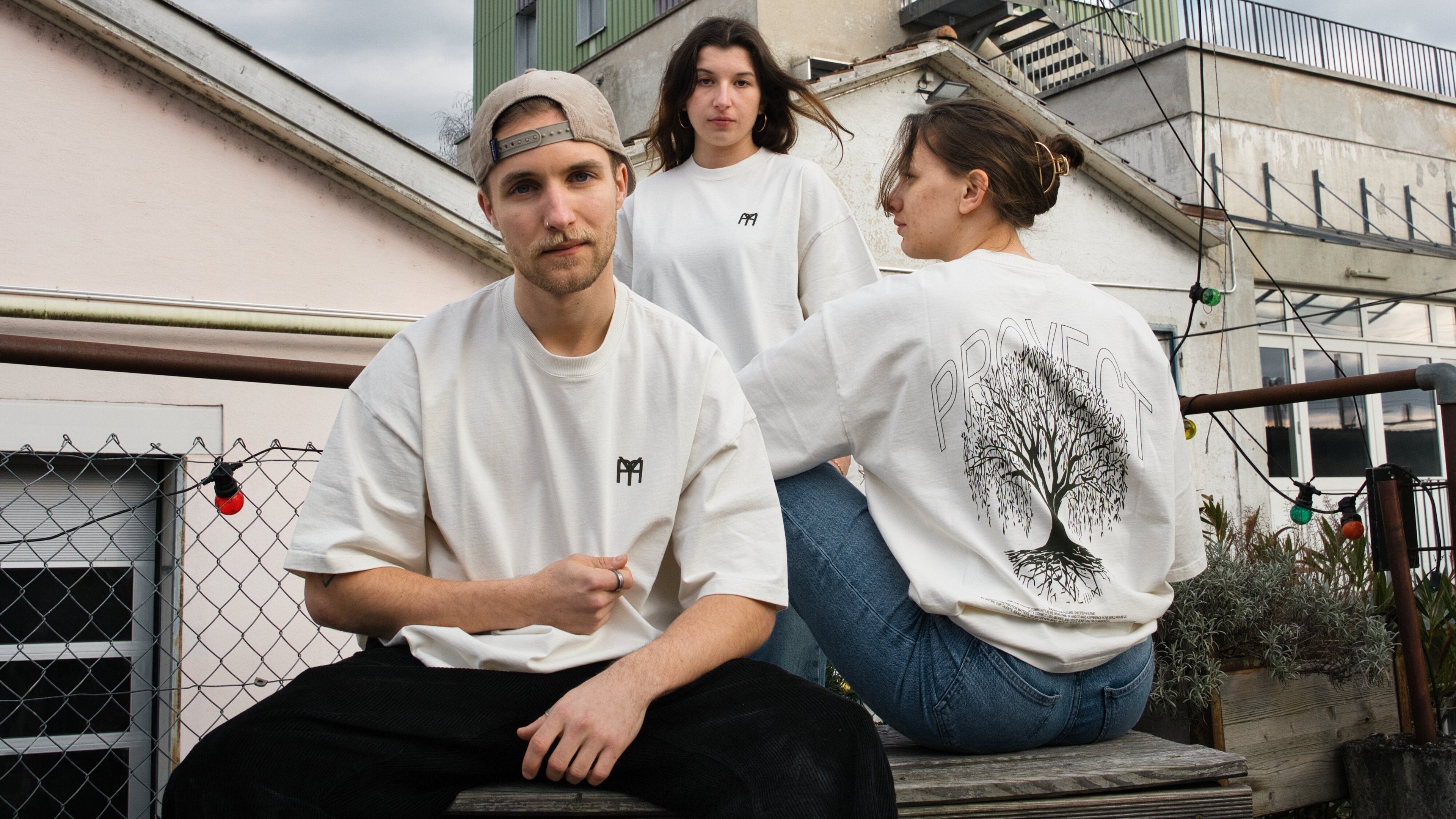 3 Models mit Tshirt von uns. Zwei schauen in unsere Richtung und eines weg von uns.